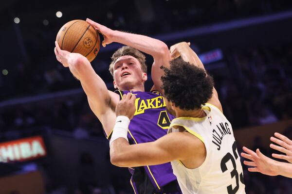 Los Angeles Lakers guard Dalton Knecht, left, attempts to score against Utah Jazz guard Johnny Juzang during the second half of an Emirates NBA Cup basketball game, Tuesday, Nov. 19, 2024, in Los Angeles. (AP Photo/Etienne Laurent)