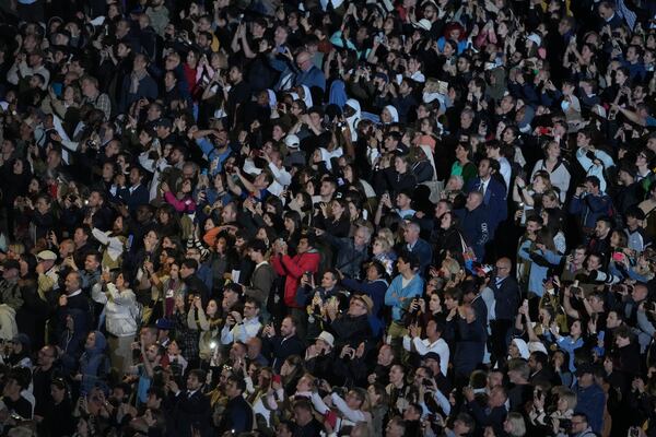 People react in St. Peter's Square at the Vatican after black smoke billowed from the chimney of the Sistine Chapel, where 133 cardinals are gathering on the first day of the conclave, indicating that a successor of late Pope Francis was not elected, Wednesday, May 7, 2025. (AP Photo/Markus Schreiber)