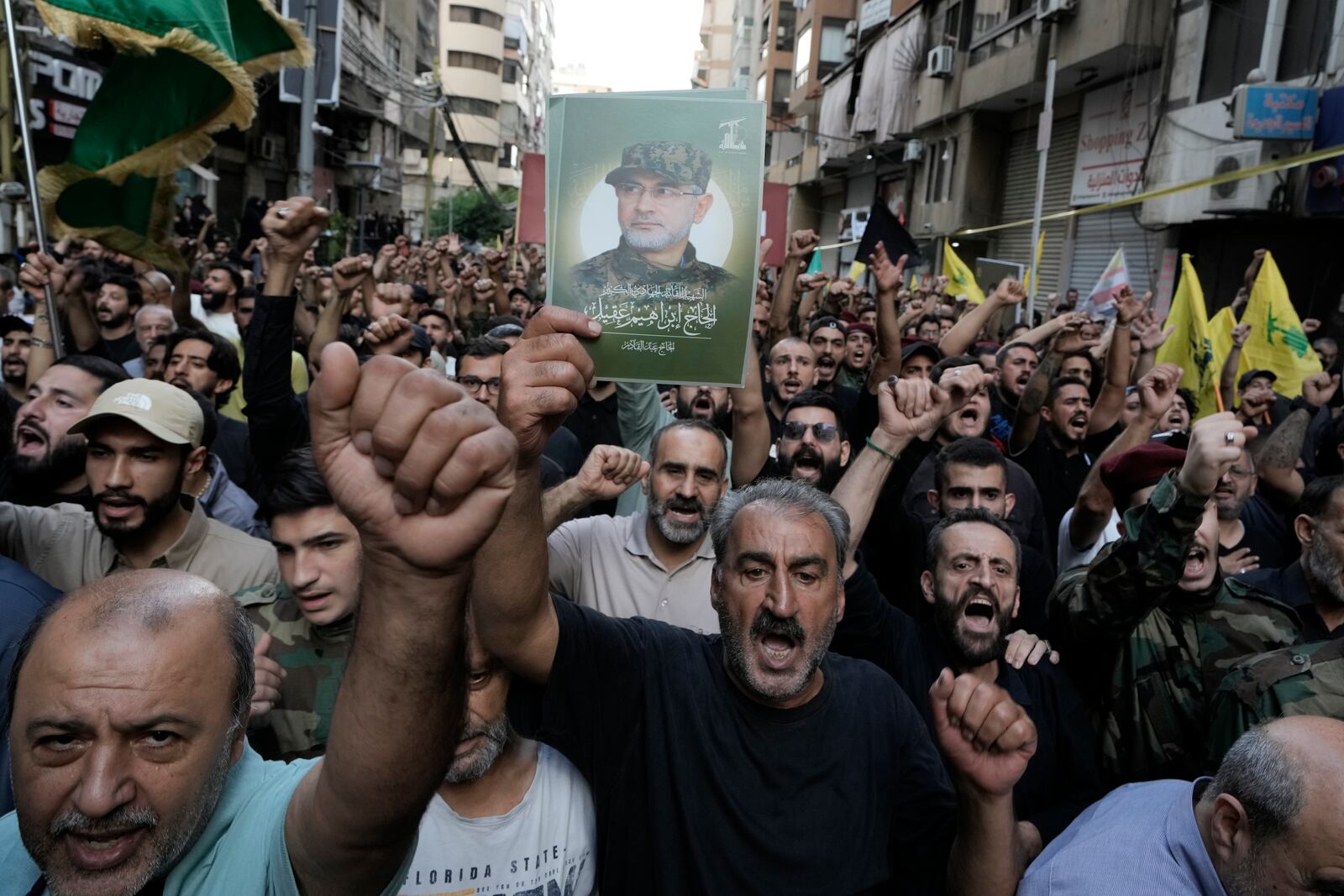 Hezbollah supporters carry pictures of Hezbollah commander Ibrahim Akil, during his funeral procession in Beirut's southern suburb, Sunday, Sept. 22, 2024. (AP Photo/Bilal Hussein)