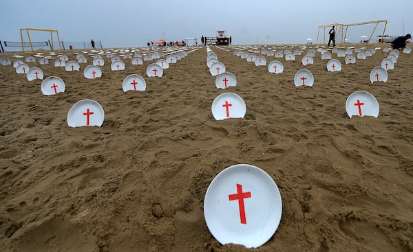 Plates marked with crosses, symbolizing people suffering from hunger worldwide, are displayed at Copacabana Beach during a protest aimed at drawing the attention of leaders attending the upcoming G20 summit in Rio de Janeiro, Saturday, Nov. 16, 2024. (AP Photo/Dhavid Normando)