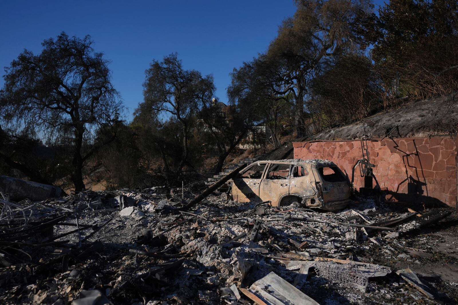 The remains of a car sits at the site of a home destroyed by the Mountain Fire in Camarillo, Calif., Friday, Nov. 8, 2024. (AP Photo/Jae C. Hong)