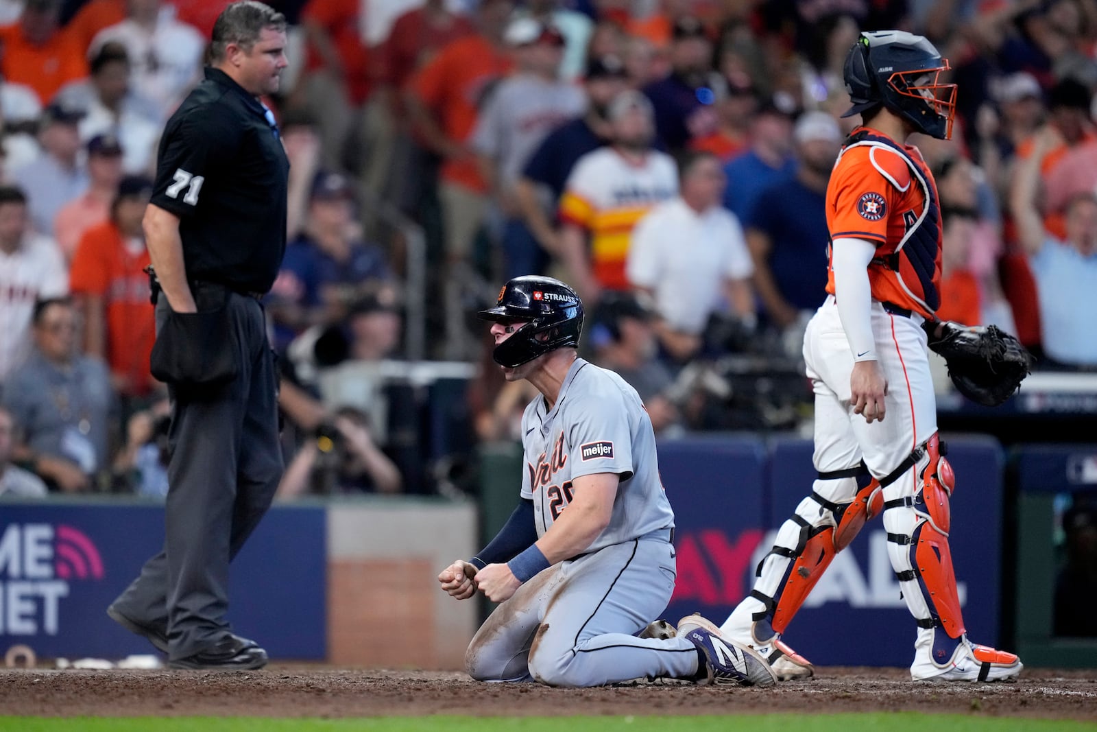 Detroit Tigers' Spencer Torkelson, center, celebrates in front of umpire Jordan Baker, left, and Houston Astros catcher Yainer Diaz, right, after Torkelson scored on a bases-clearing double by Andy Ibanez in the eighth inning of Game 2 of an AL Wild Card Series baseball game Wednesday, Oct. 2, 2024, in Houston. (AP Photo/Kevin M. Cox)