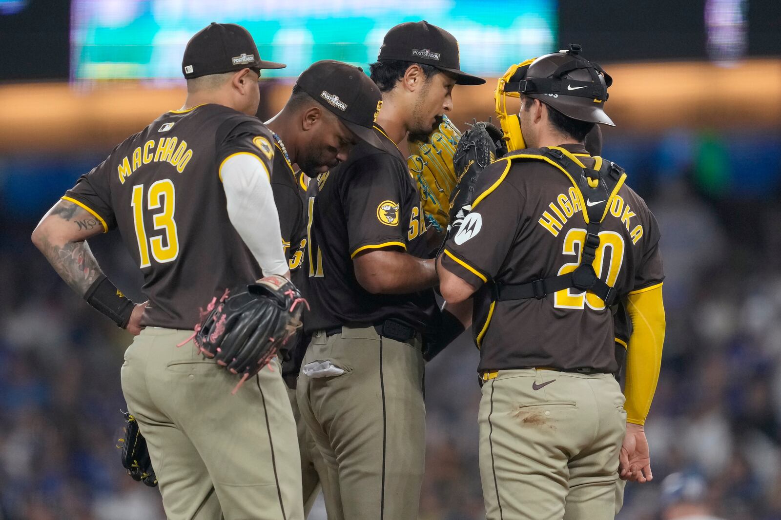 San Diego Padres pitcher Yu Darvish, middle right, talks with third baseman Manny Machado (13), shortstop Xander Bogaerts, middle left, and catcher Kyle Higashioka on the mound during the sixth inning in Game 2 of a baseball NL Division Series against the Los Angeles Dodgers, Sunday, Oct. 6, 2024, in Los Angeles. (AP Photo/Ashley Landis)