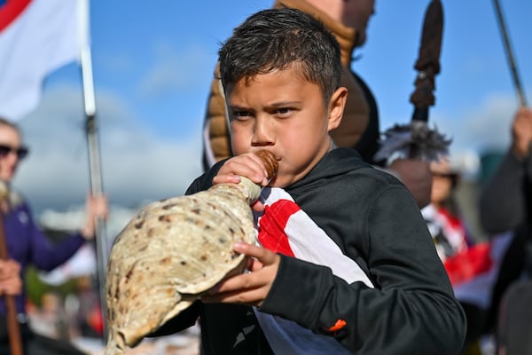 Te Haukūnui Hokianga plays a conch shell ahead of a protest at New Zealand's parliament against a proposed law that would redefine the country's founding agreement between Indigenous Māori and the British Crown, in Wellington, New Zealand, Tuesday, Nov. 19, 2024. (AP Photo/Mark Tantrum)