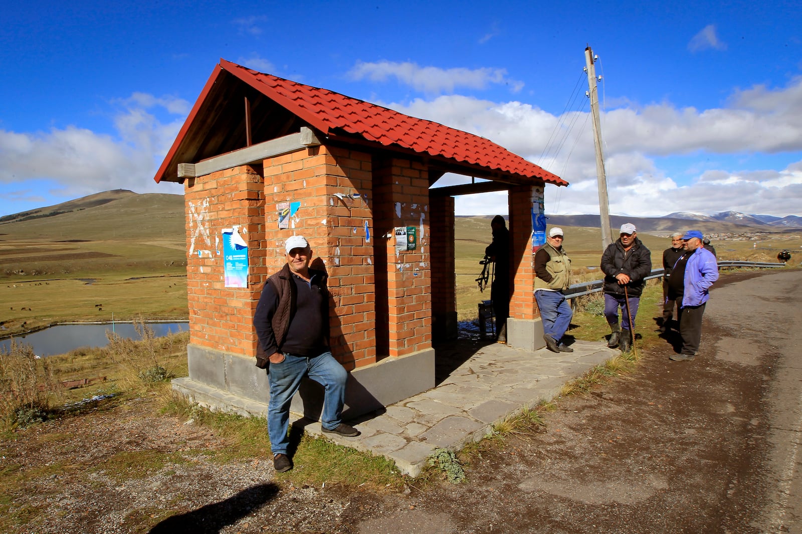 Men wait at a bus stop in the Javakheti region, Georgia, Tuesday, Oct. 22, 2024. (AP Photo/Shakh Aivazov)