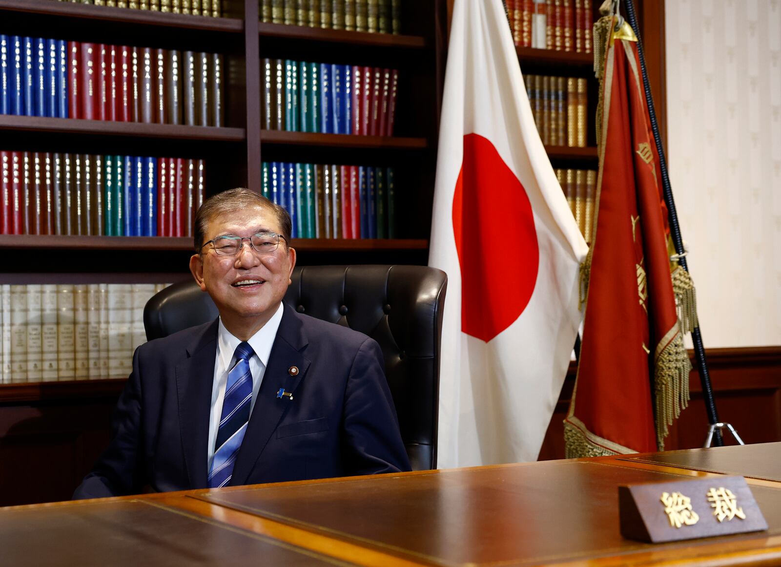 Shigeru Ishiba, the newly elected leader of Japan's ruling party, the Liberal Democratic Party (LDP) poses in the party leader's office after the LDP leadership election, in Tokyo Friday, Sept. 27, 2024. (Kim Kyung-Hoon/Pool Photo via AP)