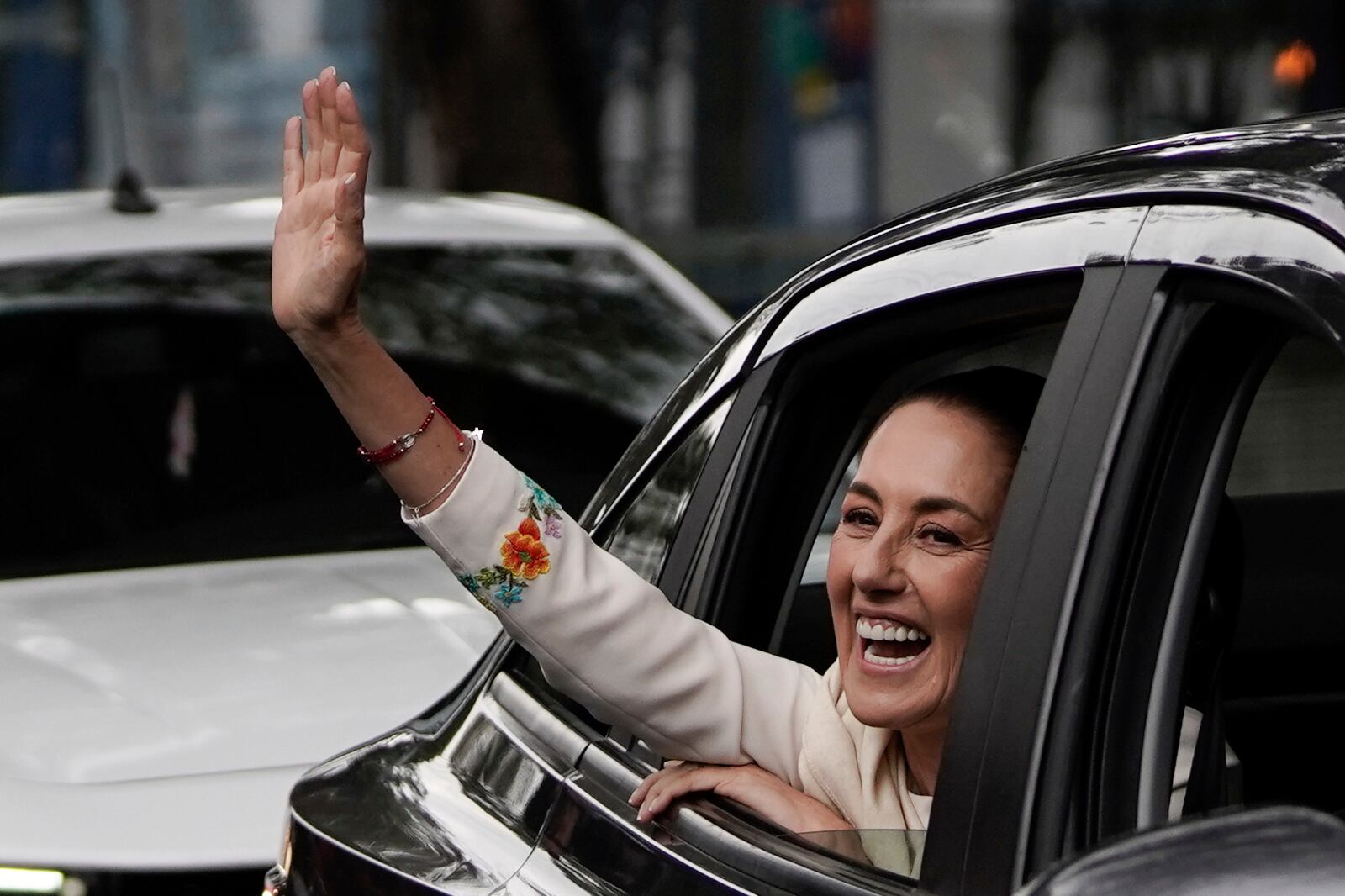 Claudia Sheinbaum waves from the vehicle taking her to Congress to assume the presidency in Mexico City, Tuesday, Oct. 1, 2024. (AP Photo/Aurea Del Rosario)