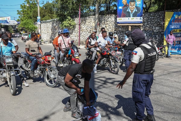 Police officers man a checkpoint checking for weapons, in the Petion-Ville of Port-au-Prince, Haiti, Tuesday, Nov. 19, 2024. (AP Photo/Odelyn Joseph)