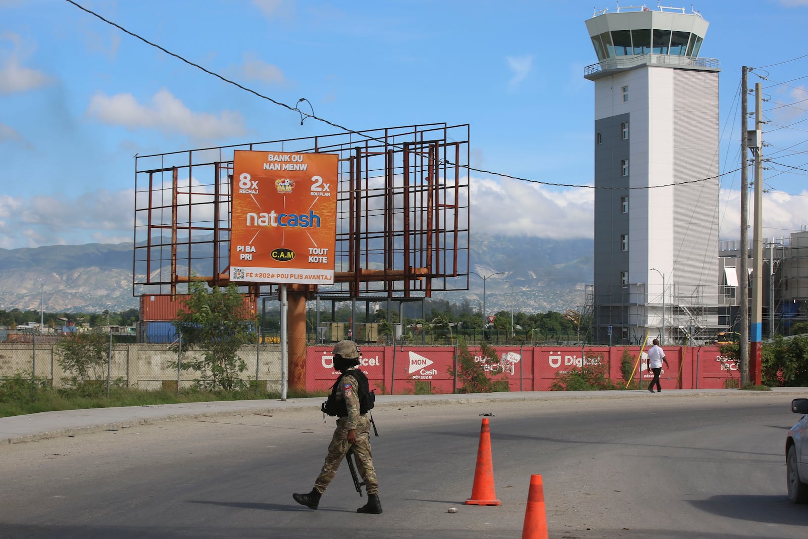 A police officer patrols the entrance of the Toussaint Louverture International Airport, in Port-au-Prince, Haiti, Tuesday, Nov. 12, 2024. (AP Photo/Odelyn Joseph)