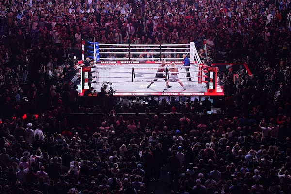 Mike Tyson, left, fights Jake Paul during their heavyweight boxing match, Friday, Nov. 15, 2024, in Arlington, Texas. (AP Photo/Julio Cortez)