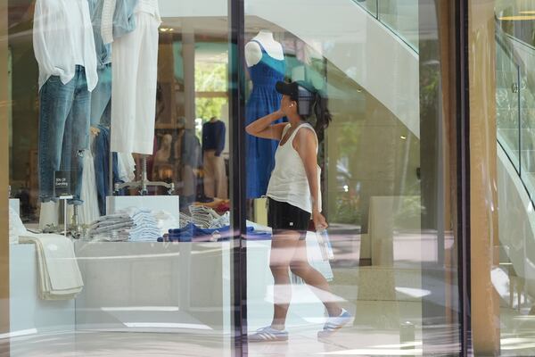 A shopper looks at a clothing display at a Gap store, Friday, April 18, 2025, in Miami Beach, Fla. (AP Photo/Marta Lavandier)