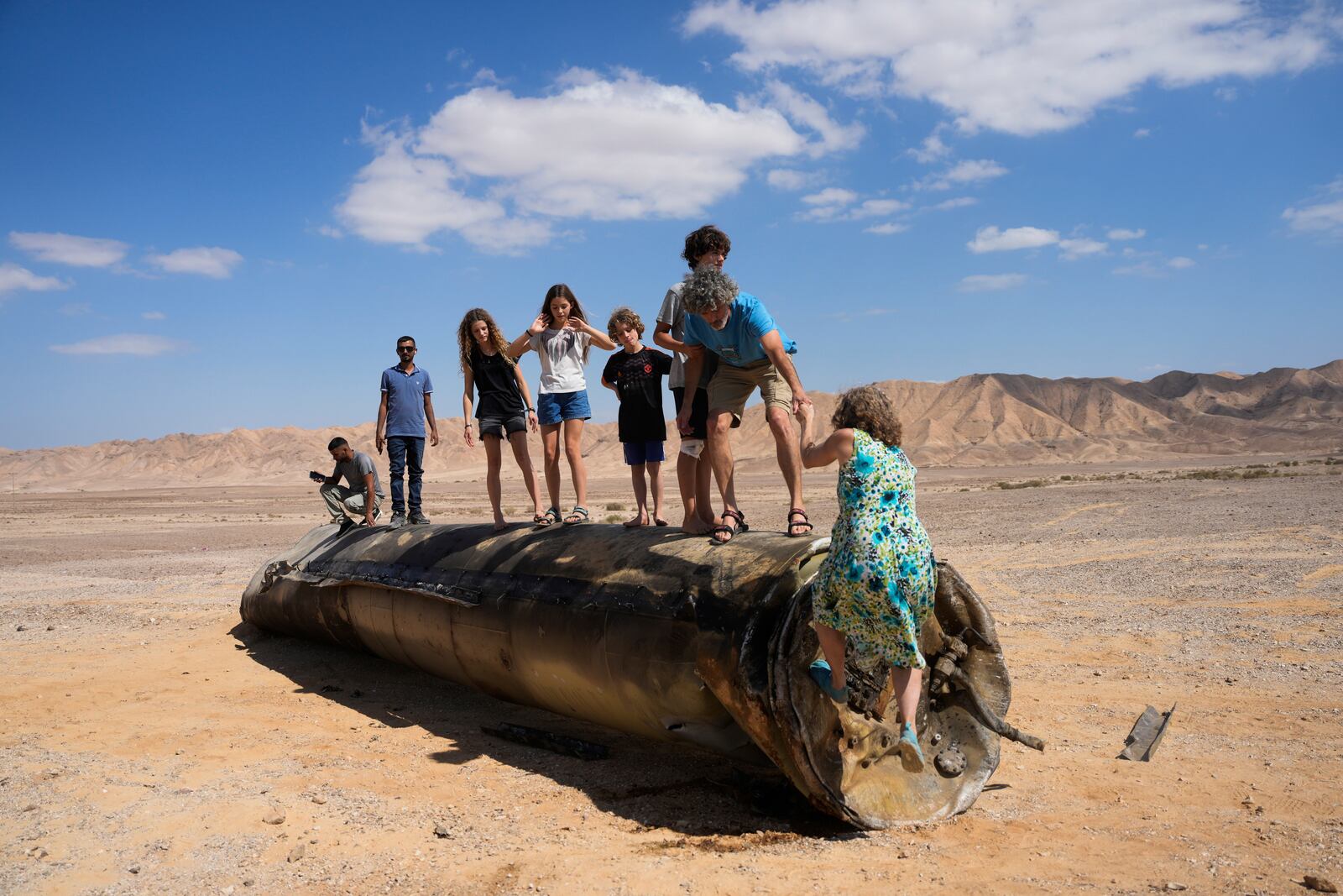 FILE - People climb on the debris of an Iranian missile intercepted by Israel, near Arad, southern Israel, Oct. 2, 2024. (AP Photo/Ohad Zwigenberg, File)