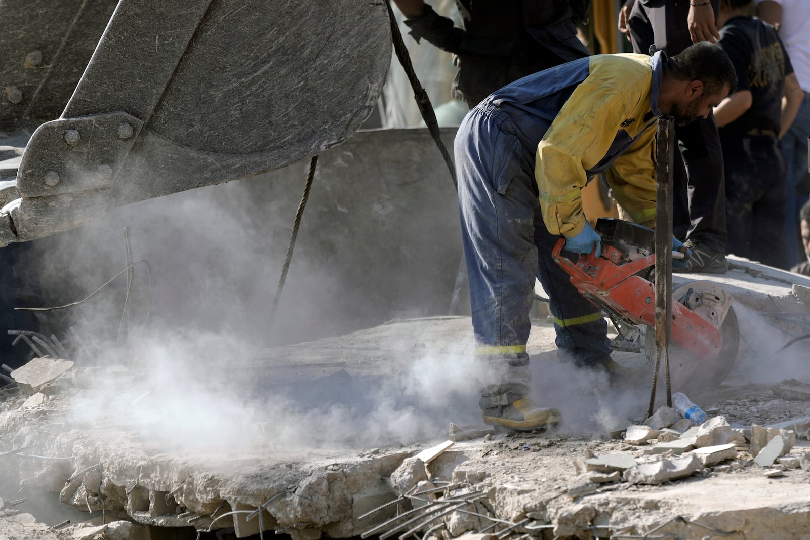 An emergency worker cuts concrete blocks as he searches for survivors at the scene of an Israeli airstrike in the town of Maisara, north of Beirut, Wednesday, Sept. 25, 2024. (AP Photo/Bilal Hussein)