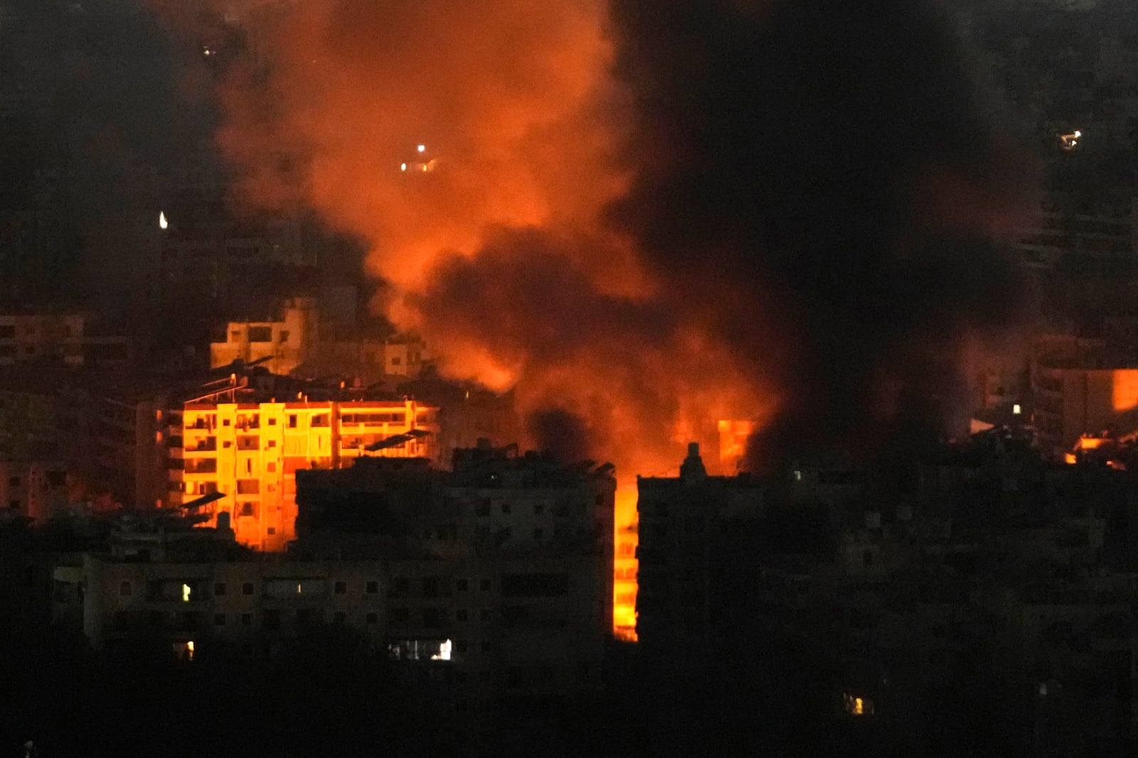 Flame and smoke rises from buildings hit by Israeli airstrikes on Dahiyeh, in the southern suburb of Beirut, Lebanon, early Sunday, Oct. 27, 2024. (AP Photo/Hussein Malla)