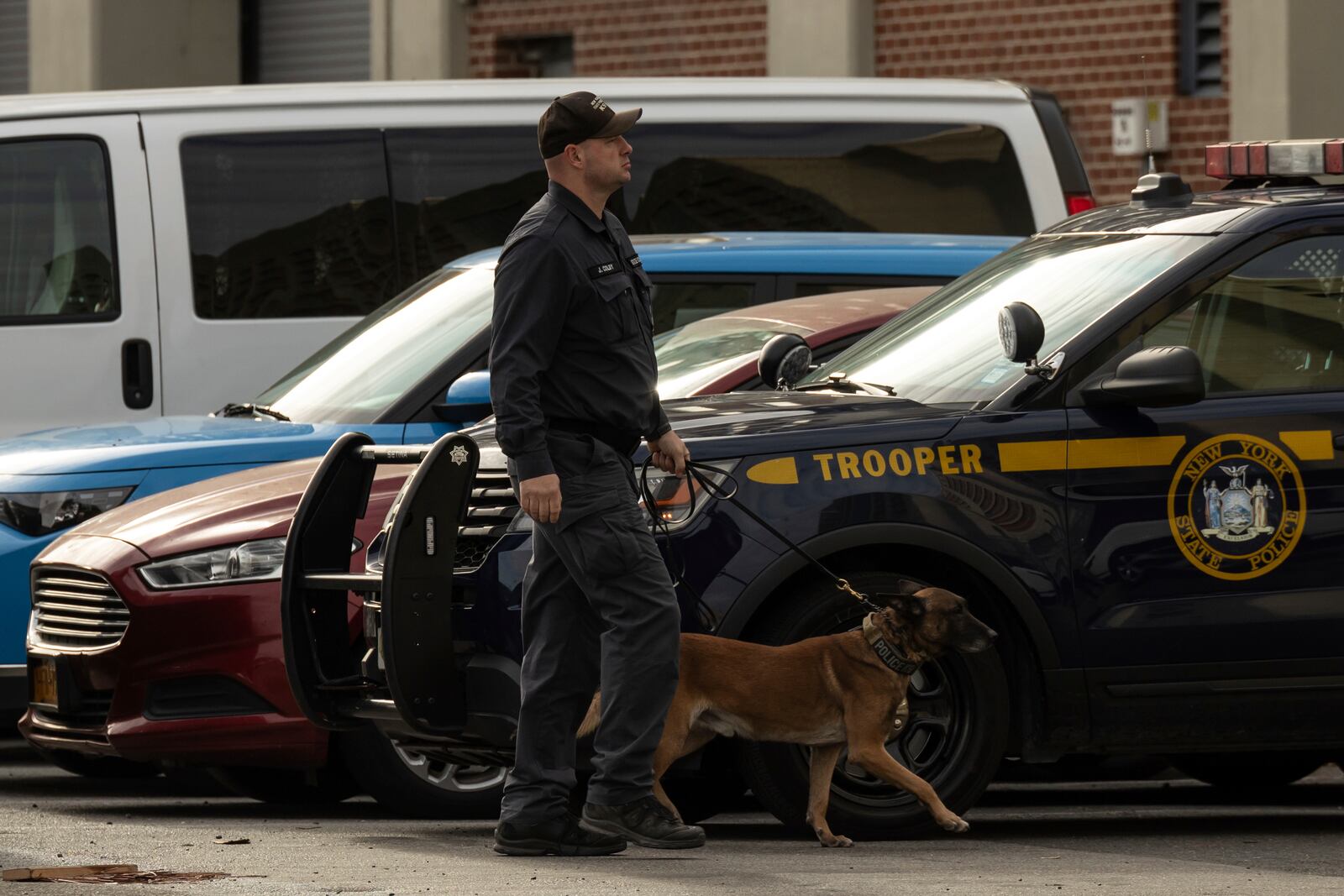 A police officer with a K-9 is seen outside the Metropolitan Detention Center during an interagency operation, Monday, Oct. 28, 2024, in the Brooklyn Borough of New York. (AP Photo/Yuki Iwamura)