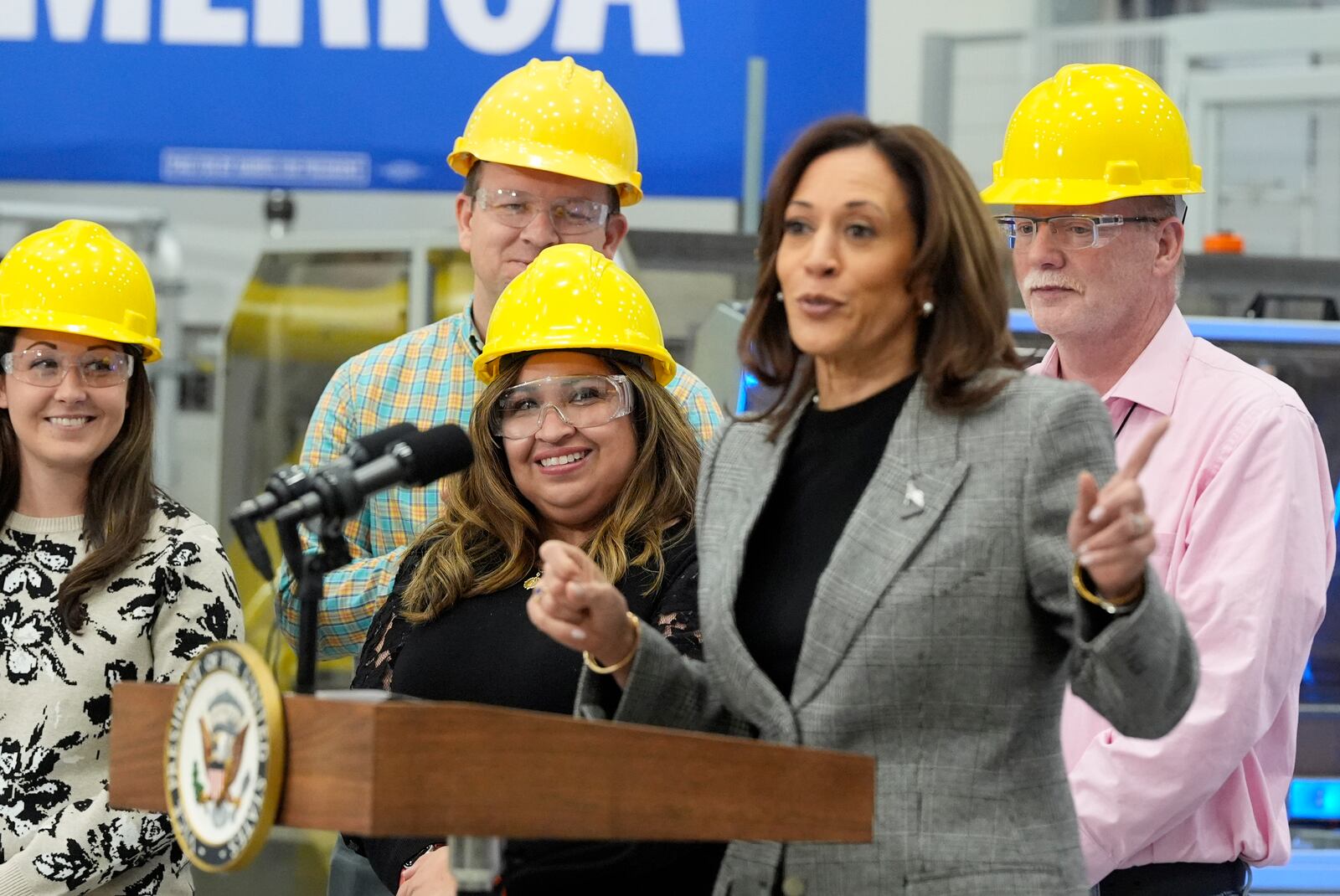 Employees watch as Democratic presidential nominee Vice President Kamala Harris speaks after taking a tour of the Hemlock Semiconductor Next-Generation Finishing facility in Hemlock, Mich., Monday, Oct. 28, 2024. (AP Photo/Jacquelyn Martin)