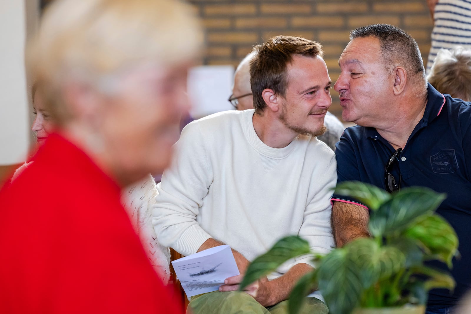 Parishioners show gratitude and connection during a service at the Don Bosco church in Buizingen, Belgium, Sunday, Sept. 8, 2024. (AP Photo/Geert Vanden Wijngaert)