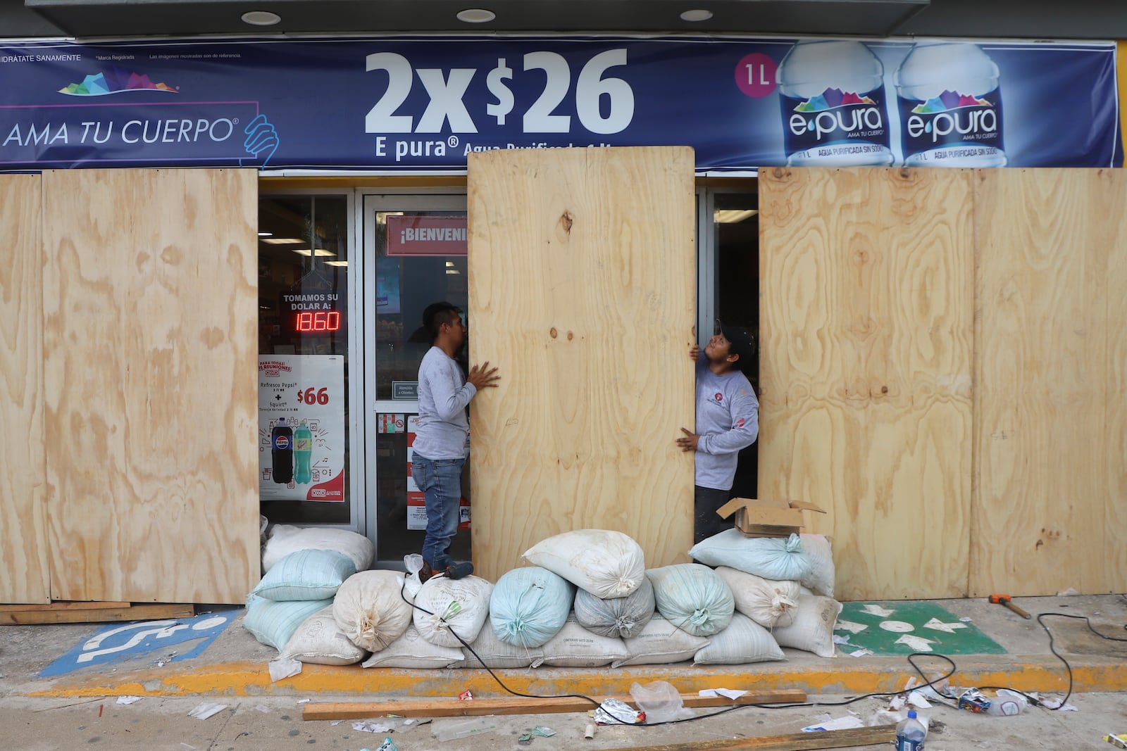 Workers board up a grocery store to protect it from Hurricane Milton, in Progreso, Yucatan state, Mexico, Monday, Oct. 7, 2024. (AP Photo/Martin Zetina)