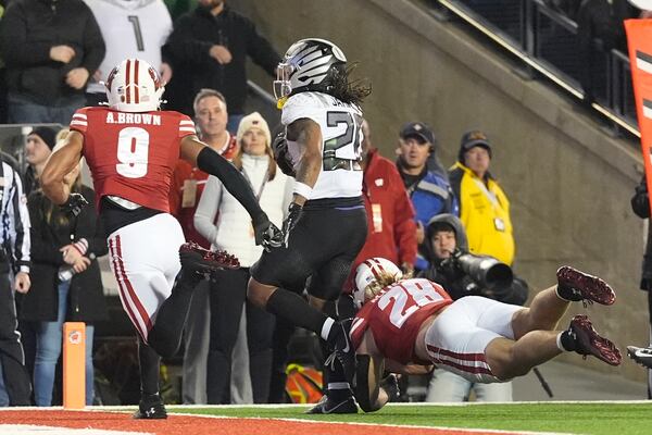 Oregon's Jordan James (20) gets past Wisconsin's Christian Alliegro (28) for a touchdown during the second half of an NCAA college football game Saturday, Nov. 16, 2024, in Madison, Wis. Oregon won 16-13. (AP Photo/Morry Gash)