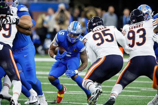 Detroit Lions running back David Montgomery (5) looks for running room as Chicago Bears defensive end DeMarcus Walker (95) defends during the first half of an NFL football game, Sunday, Nov. 17, 2024, in Detroit. (AP Photo/Carlos Osorio)