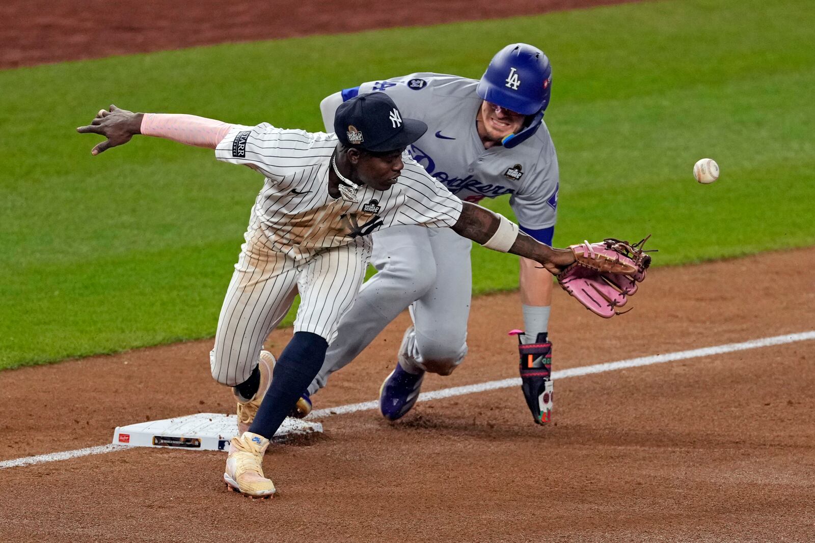 Los Angeles Dodgers' Kiké Hernández, right, is safe at third as New York Yankees third baseman Jazz Chisholm Jr. reaches for a throw from shortstop Anthony Volpe during the fifth inning in Game 5 of the baseball World Series, Wednesday, Oct. 30, 2024, in New York. Volpe was charged with a throwing error. (AP Photo/Seth Wenig)