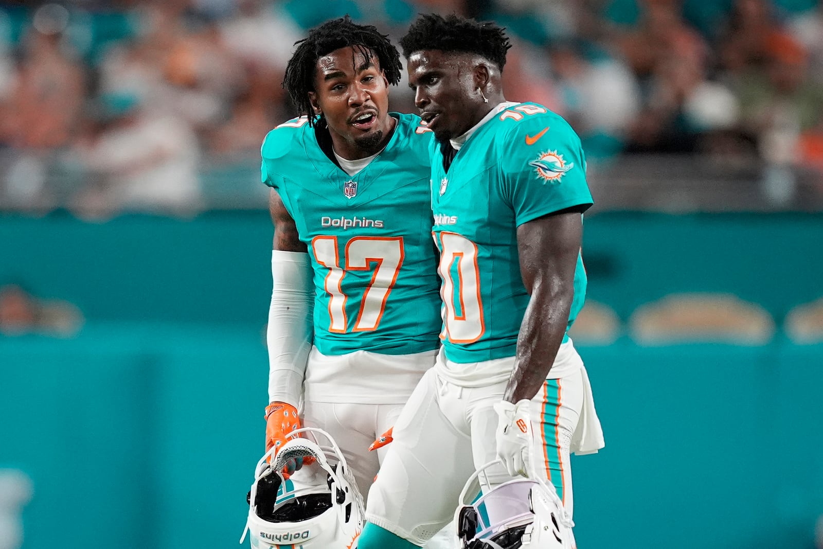 Miami Dolphins wide receiver Jaylen Waddle (17) talks to wide receiver Tyreek Hill (10) during the first half of an NFL football game against the Tennessee Titans, Monday, Sept. 30, 2024, in Miami Gardens, Fla. (AP Photo/Rebecca Blackwell)