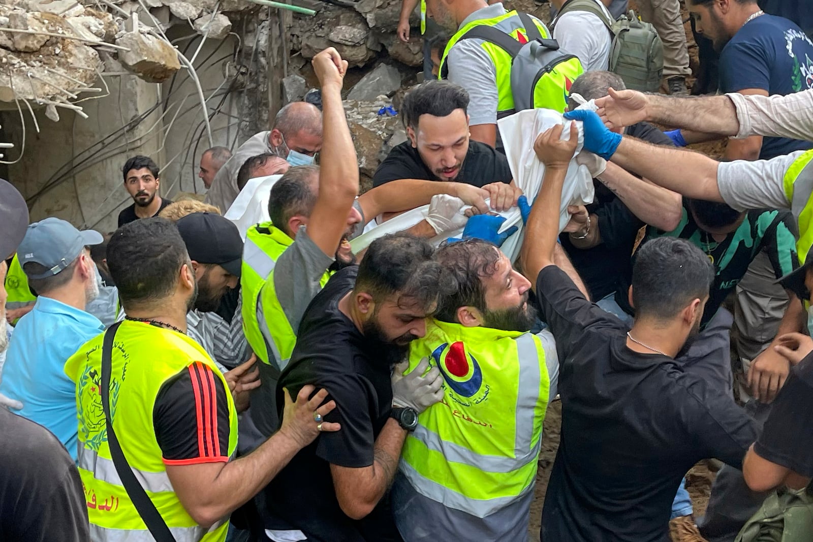 Rescuers carry a body at the scene of a missile strike in the southern suburbs of Beirut, Friday, Sept. 20, 2024. (AP Photo/Bilal Hussein)