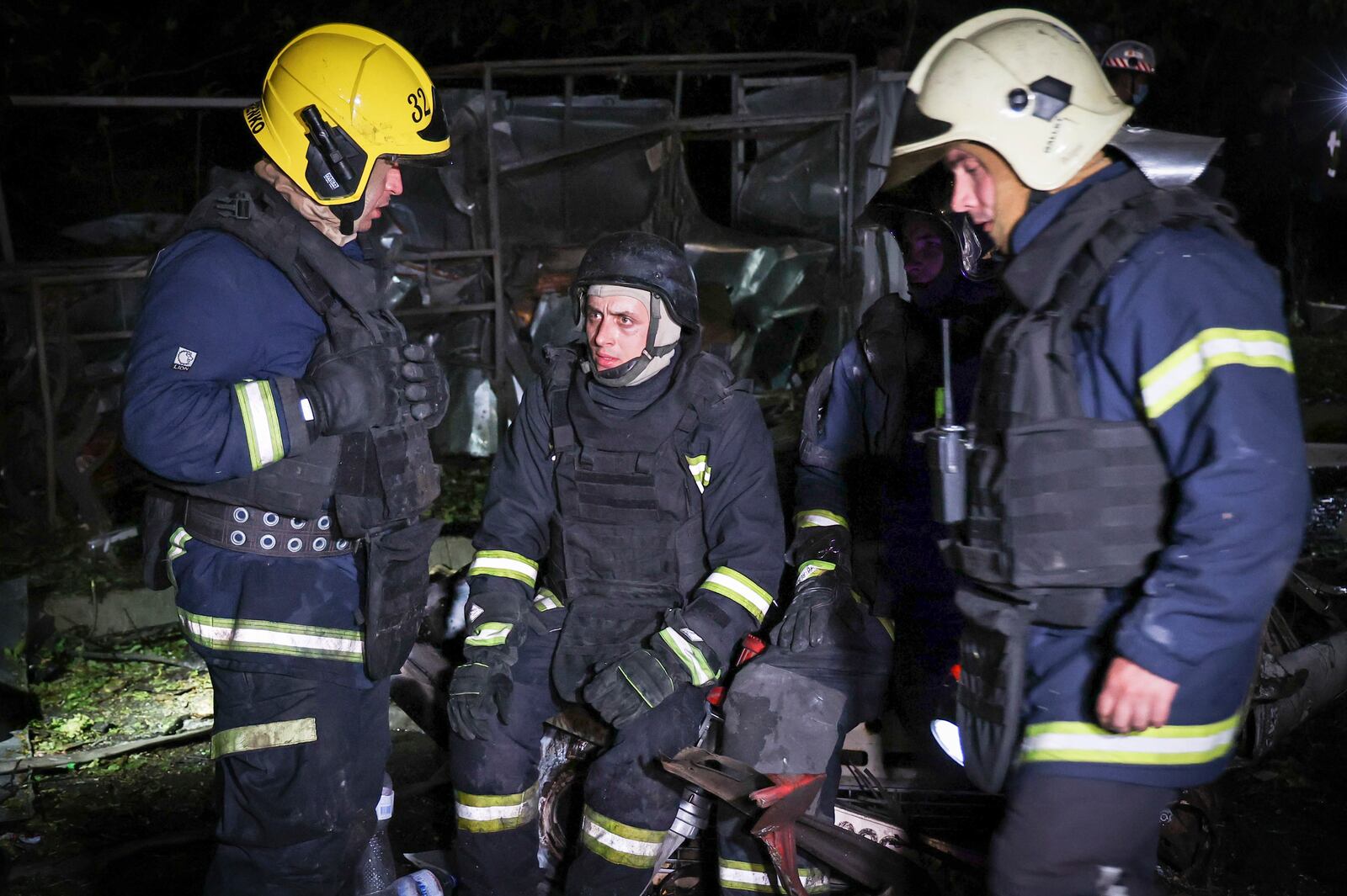 Firefighters take a break after working at the scene after a Russian strike on a residential building in Kharkiv, Ukraine early Sunday Sept. 22, 2024. (Kharkiv Regional Military Administration via AP)