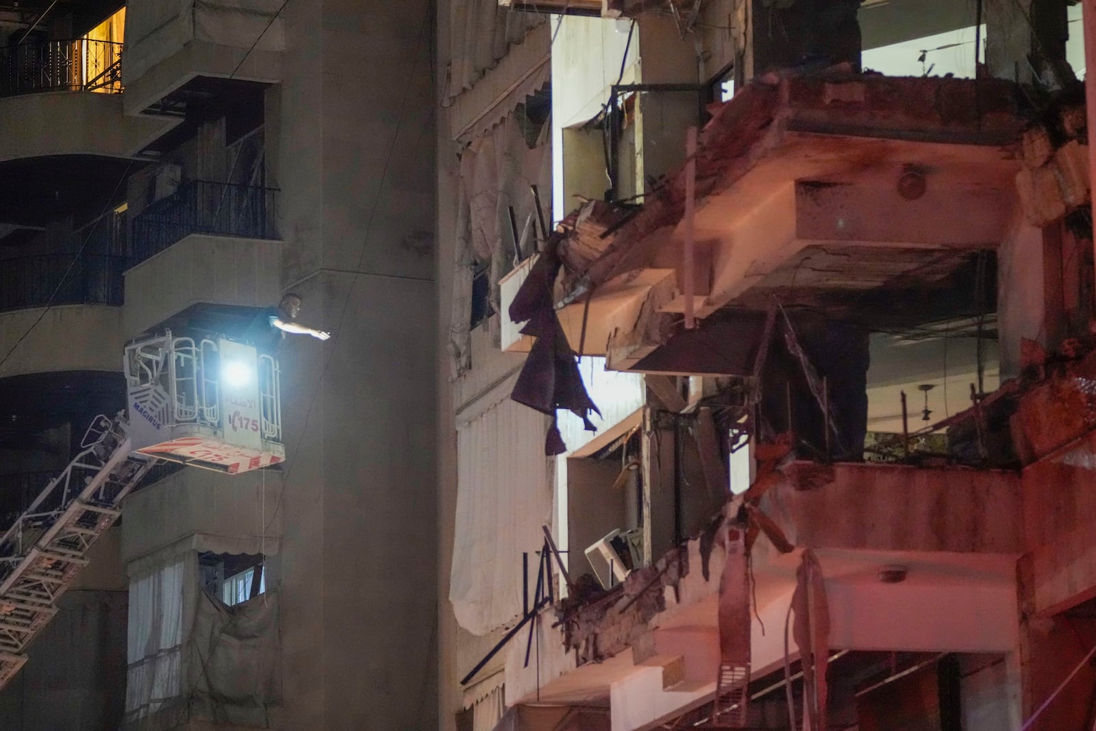 A rescue worker searches for survivors inside a damaged building hit by an Israeli airstrike in Beirut, Lebanon, Thursday, Oct. 10, 2024. (AP Photo/Hassan Ammar)