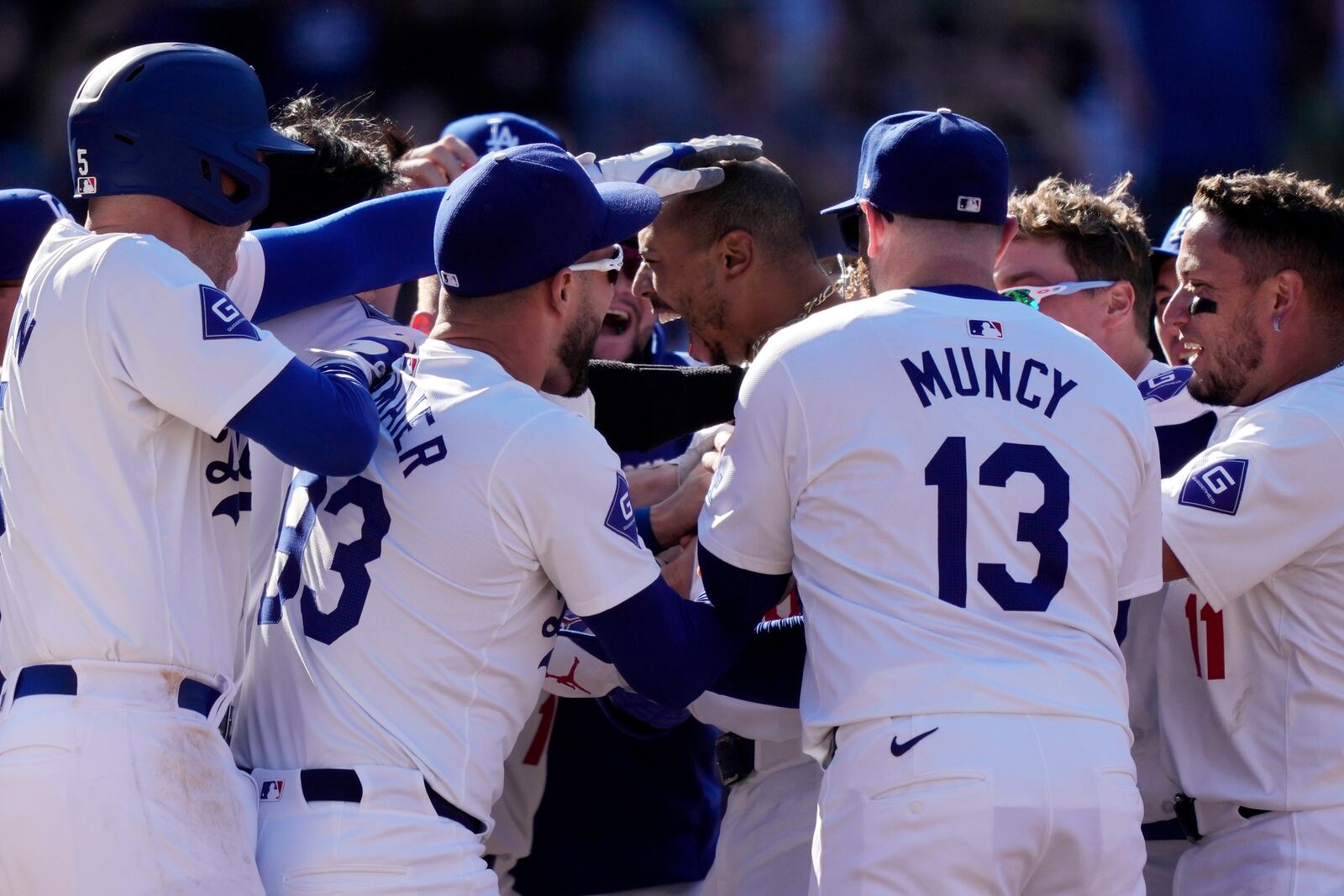 Los Angeles Dodgers' Mookie Betts, center, celebrates with teammates after hitting a walk-off solo home run during the ninth inning of a baseball game against the Colorado Rockies, Sunday, Sept. 22, 2024, in Los Angeles. The Dodgers won 6-5. (AP Photo/Mark J. Terrill)