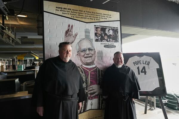 Father Tom McCarthy, left, and Brother Joe Ruiz, right, pose for a photo after a news conference for the Chicago White Sox's commemoration of team fan Pope Leo XIV with a graphic installation at Rate Field before a baseball game between the Seattle Mariners and the White Sox in Chicago, Monday, May 19, 2025. (AP Photo/Nam Y. Huh)