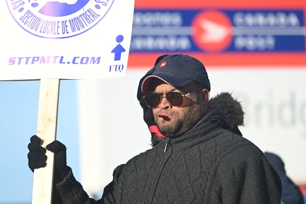 Canada Post workers picket outside a sorting plant in Montreal on Friday, Nov.15, 2024. (Graham Hughes /The Canadian Press via AP)