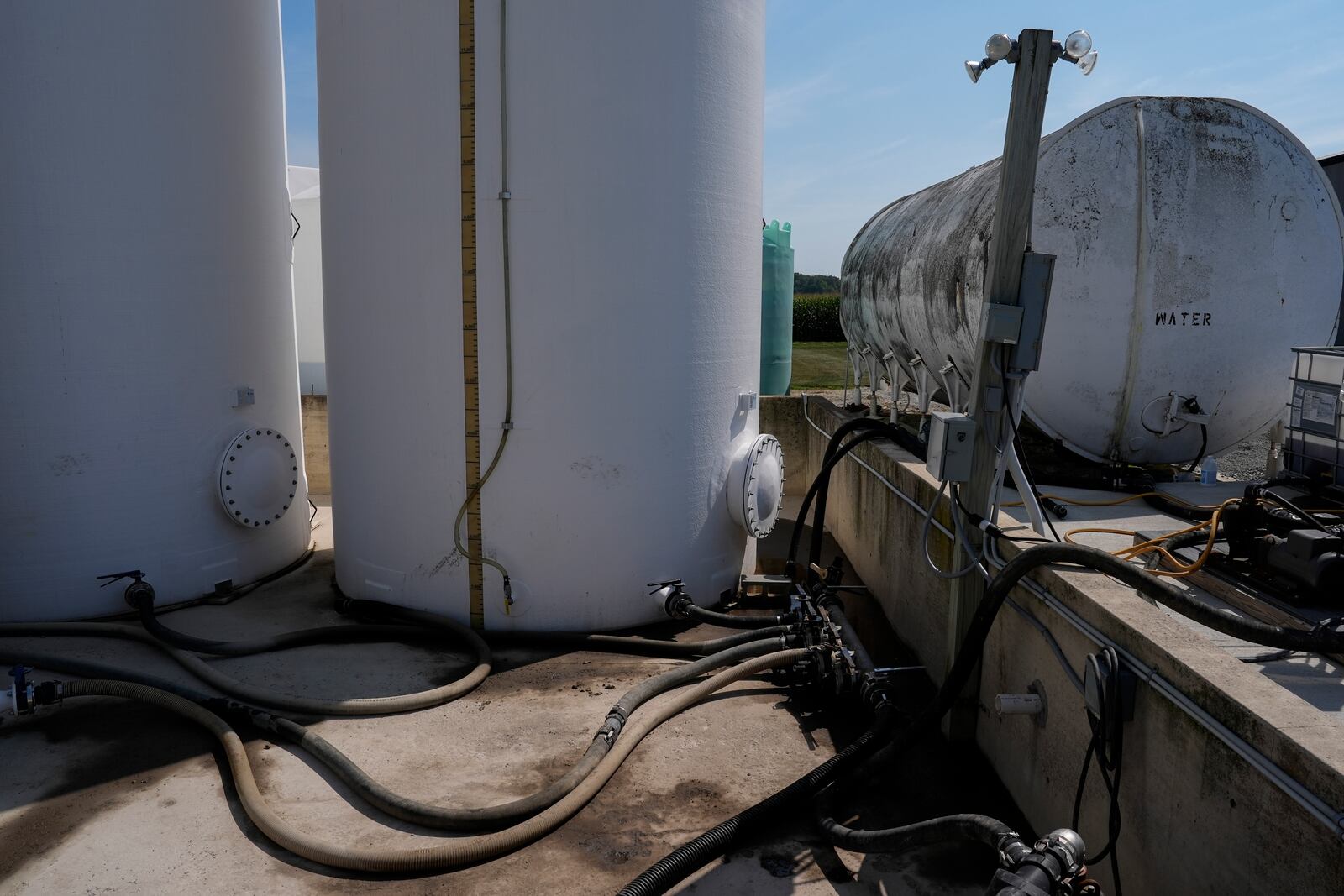 Liquid fertilizer tanks sit in a concrete basin, designed to contain any potential leaks, Tuesday, Aug. 27, 2024, at a farm in Forest, Ohio. (AP Photo/Joshua A. Bickel)