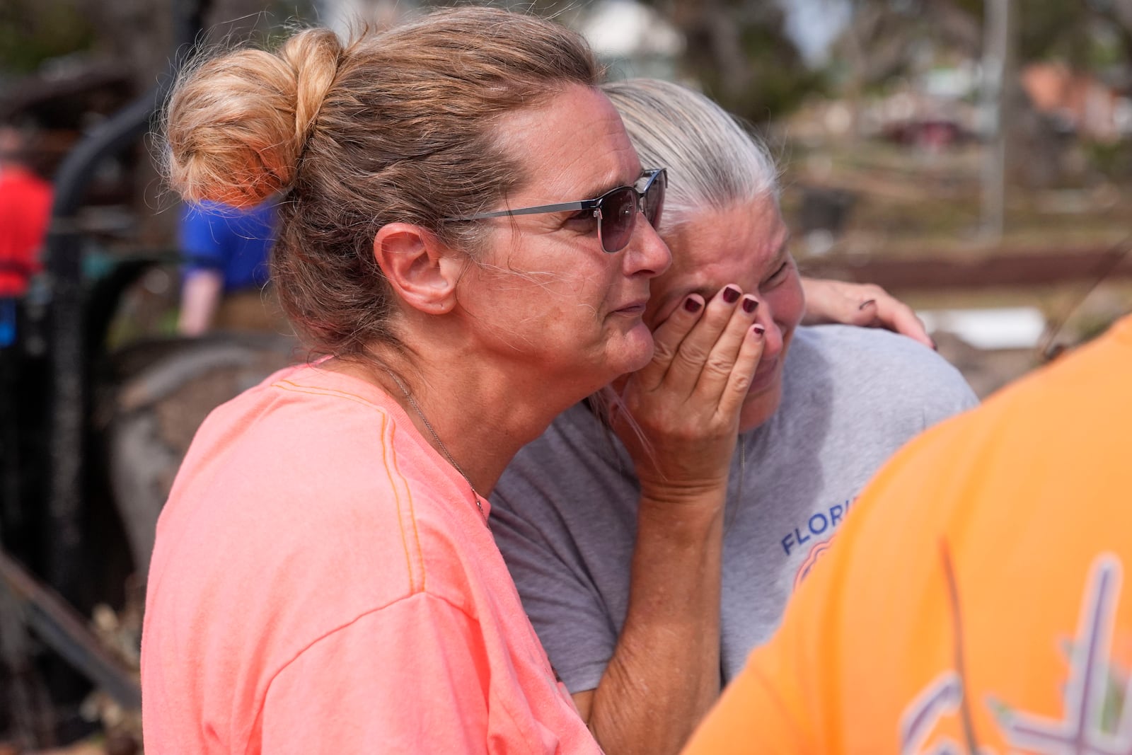 Tammy Bryan, left, hugs fellow resident Jennifer Lange amid the destruction in the aftermath of Hurricane Helene, in Horseshoe Beach, Fla., Saturday, Sept. 28, 2024. (AP Photo/Gerald Herbert)