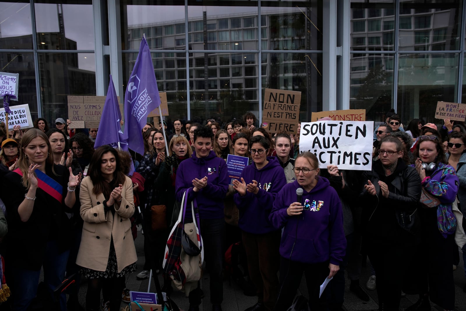 Women's rights activists demonstrate outside the Paris palace of justice as French actor Gérard Depardieu, who is facing trial for the alleged sexual assaults of two women on a film set in 2021, won't appear before a criminal court, Monday, Oct. 28, 2024 in Paris. (AP Photo/Louise Delmotte)