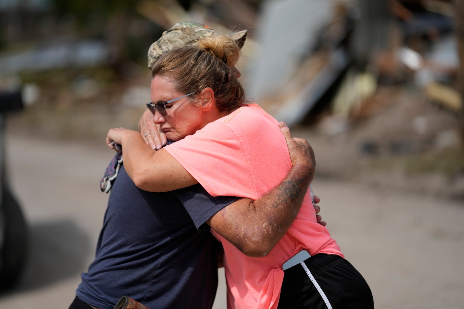 Tammy Bryan hugs fellow resident Mark Johnson amid the destruction in the aftermath of Hurricane Helene, in Horseshoe Beach, Fla., Saturday, Sept. 28, 2024. (AP Photo/Gerald Herbert)