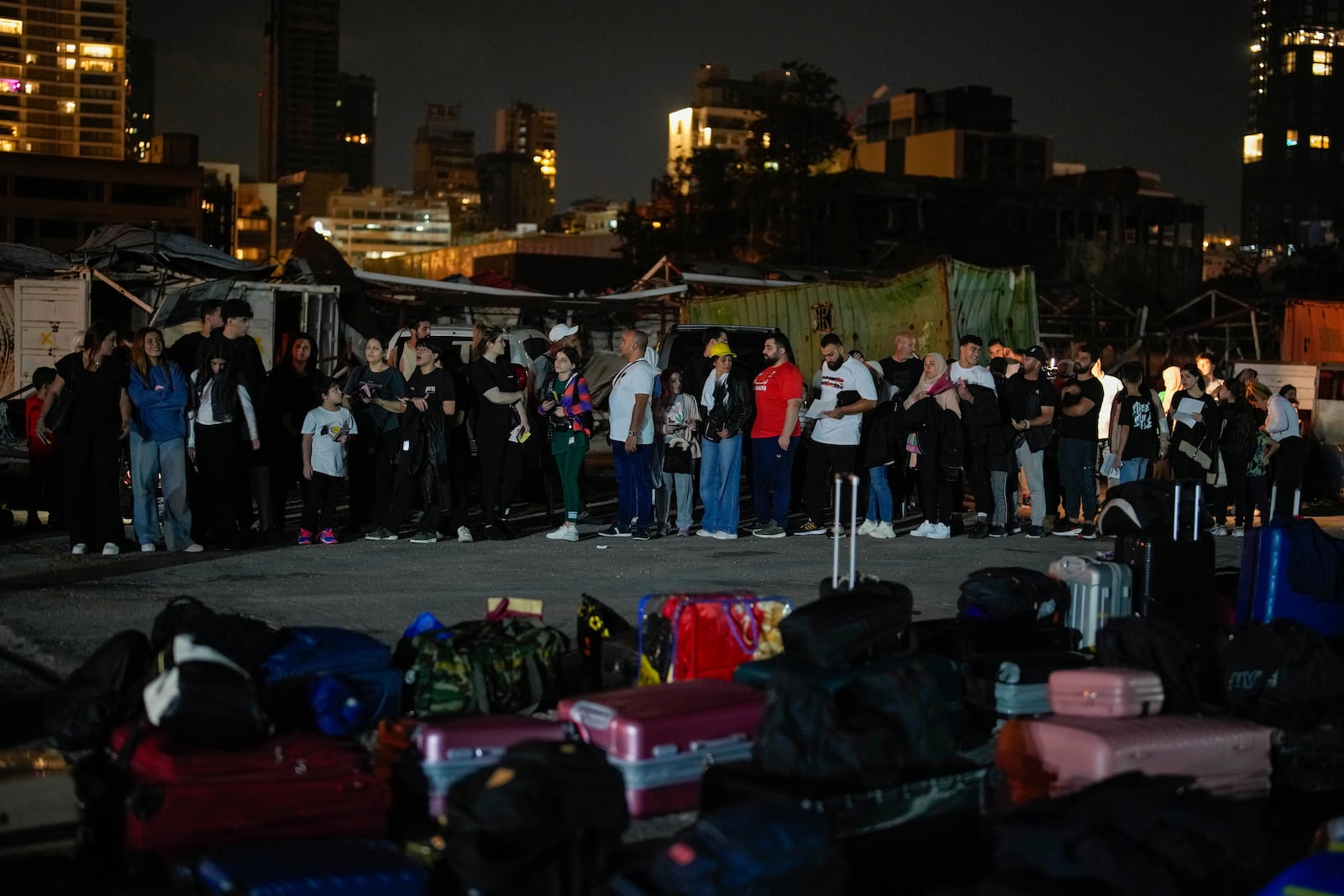 Turkish citizens stand in line waiting for their turn to board two Turkish military ships to evacuate them from Lebanon to Turkey, in Beirut port, Wednesday, Oct. 9, 2024. (AP Photo/Emrah Gurel)