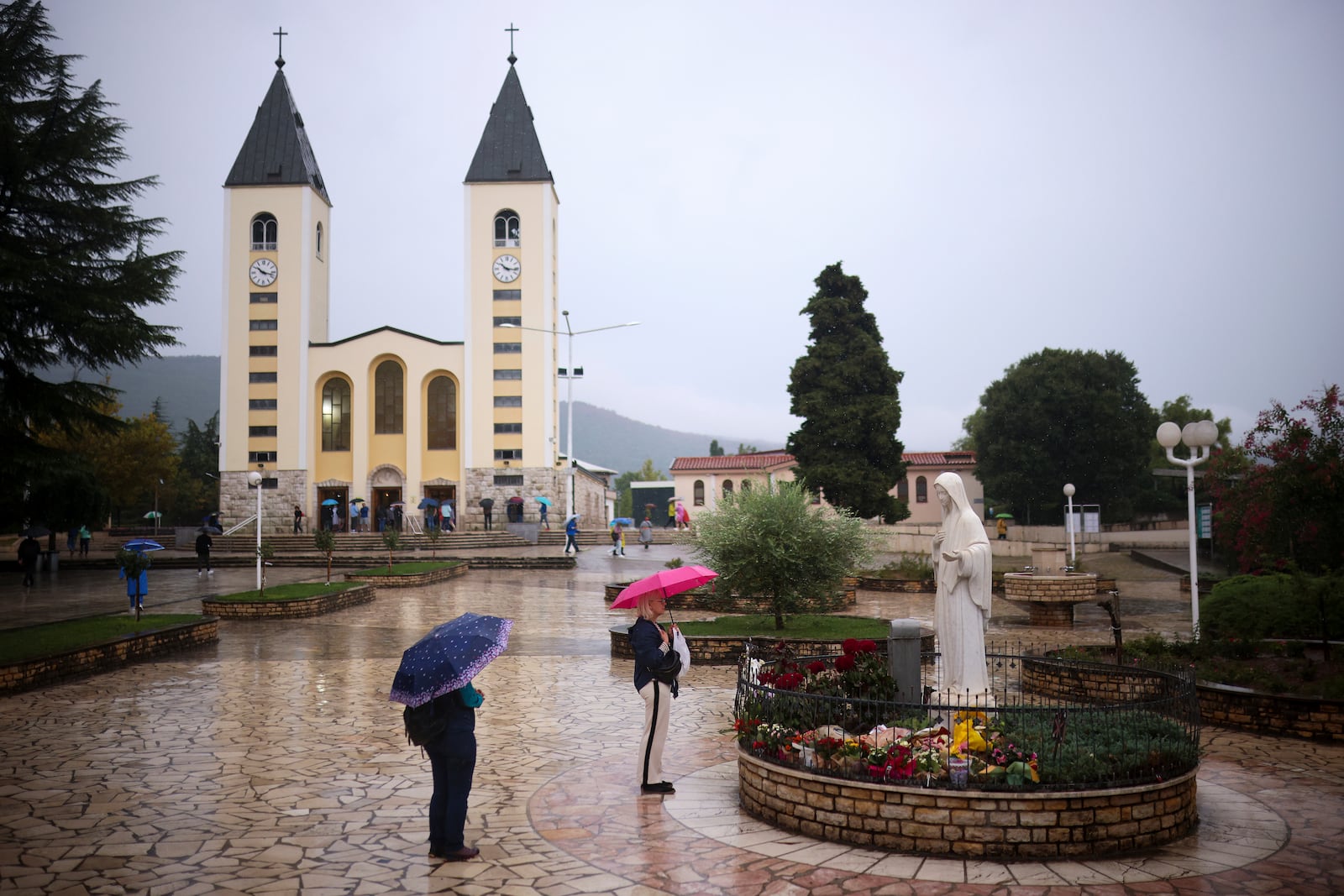 Pilgrims say their prayers next to the statue of the Virgin Mary in Medjugorje, Bosnia, Thursday, Sept. 19, 2024. (AP Photo/Armin Durgut)