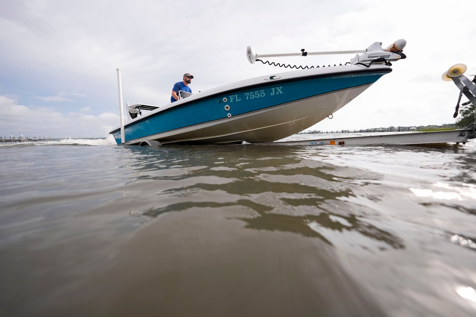 Bo Manausa pulls his boot out of the water ahead of Hurricane Helene, expected to make landfall Thursday evening, in Alligator Point, Fla., Wednesday, Sept. 25, 2024. (AP Photo/Gerald Herbert)