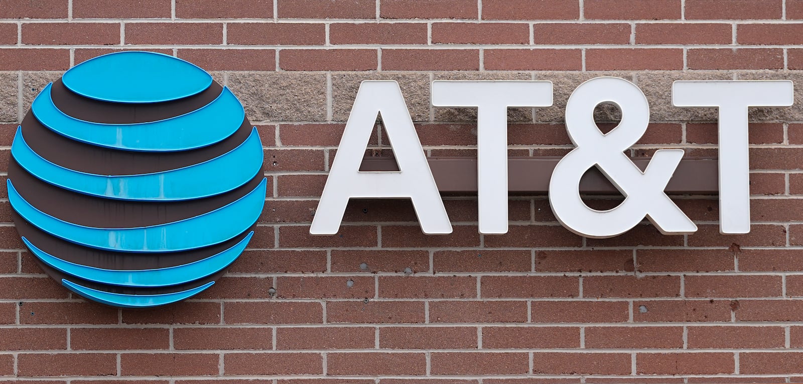 FILE - The company logo hangs over the door to a AT&T telephone store Thursday, Feb. 22, 2024, in Denver. (AP Photo/David Zalubowski, File)