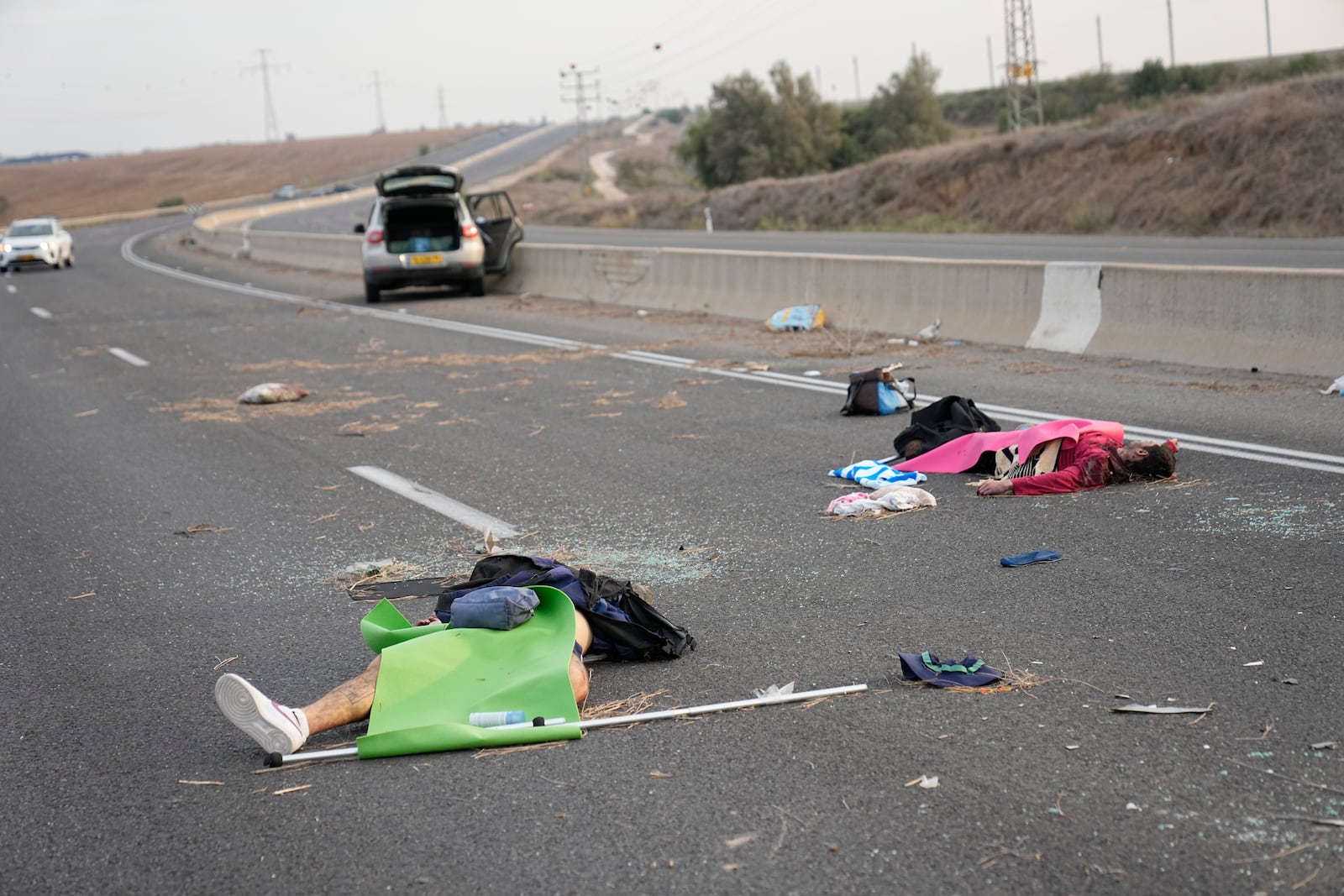 Israelis killed by Hamas militants lie on the road near Sderot, Israel, on Oct. 7, 2023. (AP Photo/Ohad Zwigenberg)