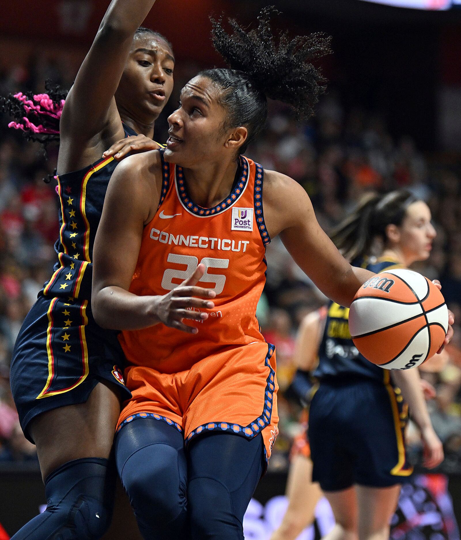 Connecticut Sun's Alyssa Thomas (25) attempts to move past Indiana Fever's Aliyah Boston, left, at the net during a first-round WNBA basketball playoff game at Mohegan Sun Arena, Sunday, Sept. 22, 2024. (Sarah Gordon/The Day via AP)