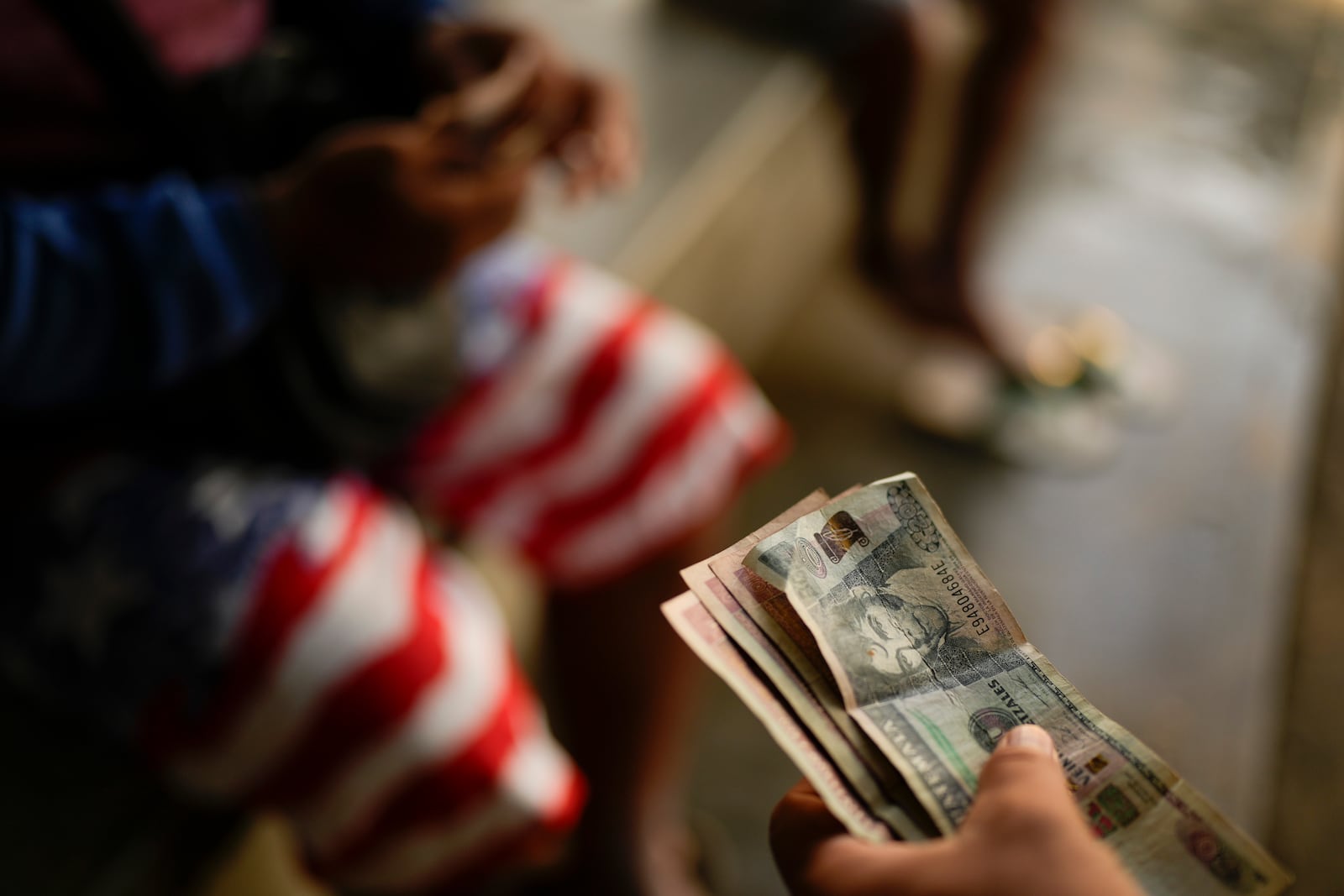 Honduran migrant Gerzon Zavala exchanges quetzal bills to Mexican pesos after crosses the Suchiate River, which marks the border between Guatemala and Mexico, from Ciudad Hidalgo, Mexico, Monday, Oct. 28, 2024. (AP Photo/Matias Delacroix)