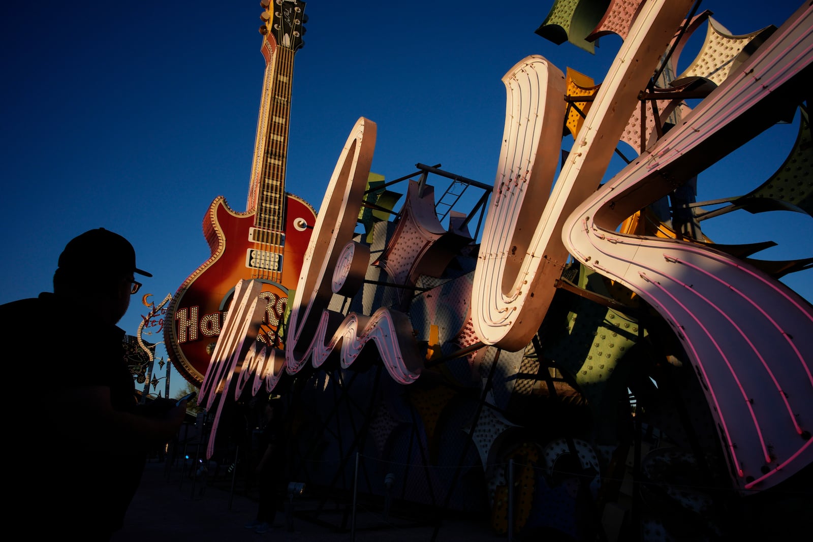 People look at signs from defunct Las Vegas casinos on display at the Neon Museum, Wednesday, April 3, 2024, in Las Vegas. (AP Photo/John Locher)