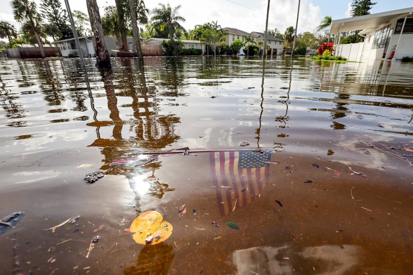 FILE - An American flag sits in floodwaters in the aftermath of Hurricane Helene in the Shore Acres neighborhood Sept. 27, 2024, in St. Petersburg, Fla. (AP Photo/Mike Carlson, File)