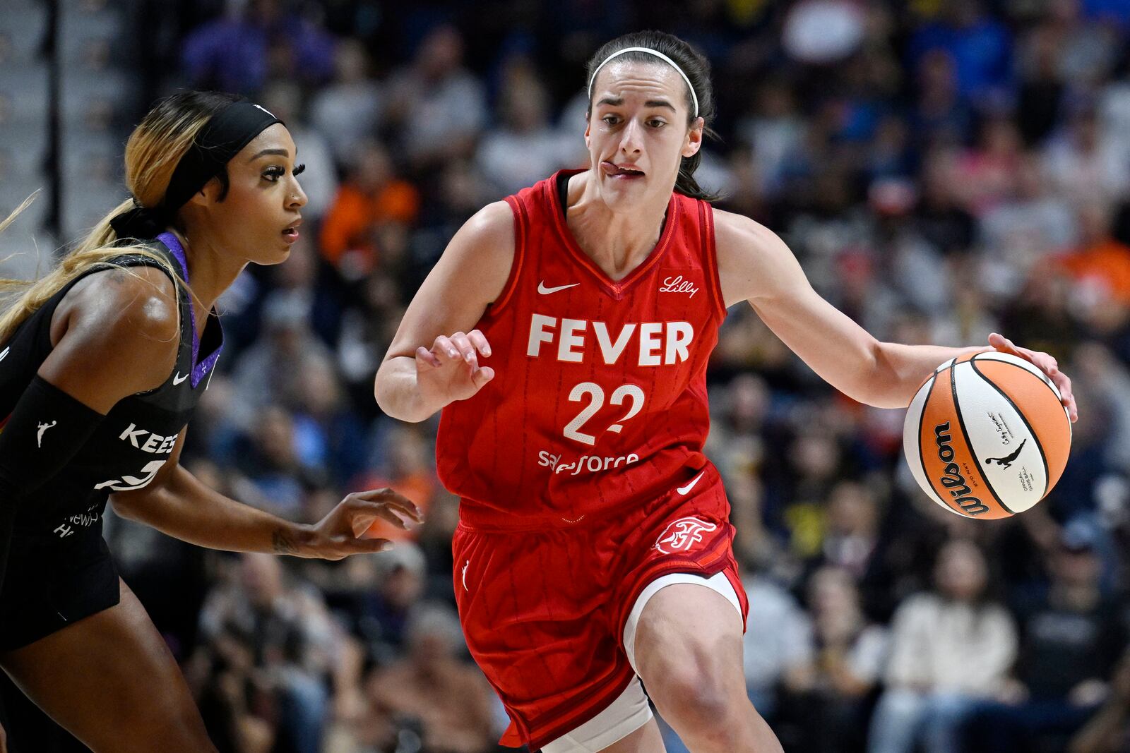 Indiana Fever guard Caitlin Clark (22) drives to the basket as Connecticut Sun guard DiJonai Carrington defends during a first-round WNBA basketball playoff game, Wednesday, Sept. 25, 2024, in Uncasville, Conn. (AP Photo/Jessica Hill)