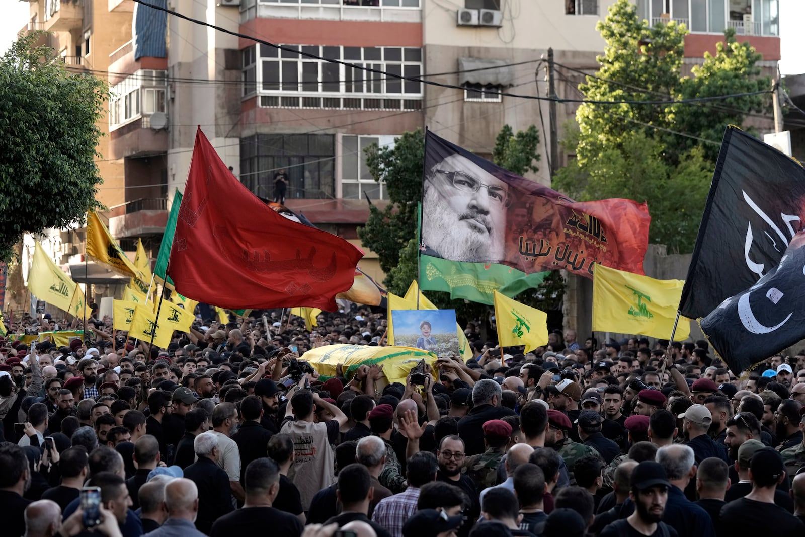 Hezbollah supporters carry the coffin of their comrade who was killed in Friday's Israeli strike, during his funeral procession in the southern suburb of Beirut, Saturday, Sept. 21, 2024. (AP Photo/Bilal Hussein)