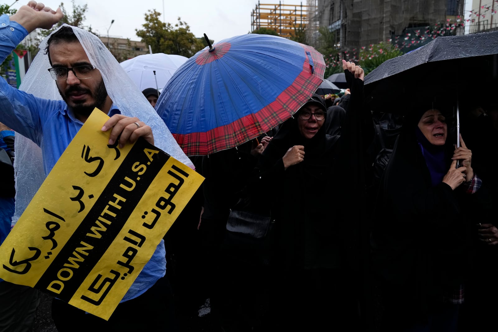 Iranian demonstrators chant slogans as one of them holds an anti-U.S. placard in a gathering to support Lebanon's militant Hezbollah group at the Felestin (Palestine) Sq. in downtown Tehran, Iran, Saturday, Sept. 28, 2024. (AP Photo/Vahid Salemi)