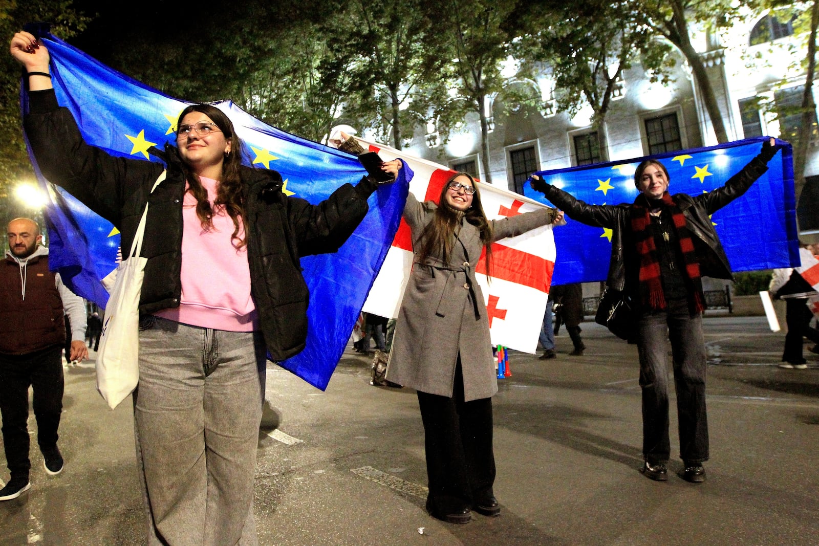 People hold EU and Georgian flags during an opposition protest against the results of the parliamentary election in Tbilisi, Georgia, Monday, Oct. 28, 2024. (AP Photo/Shakh Aivazov)