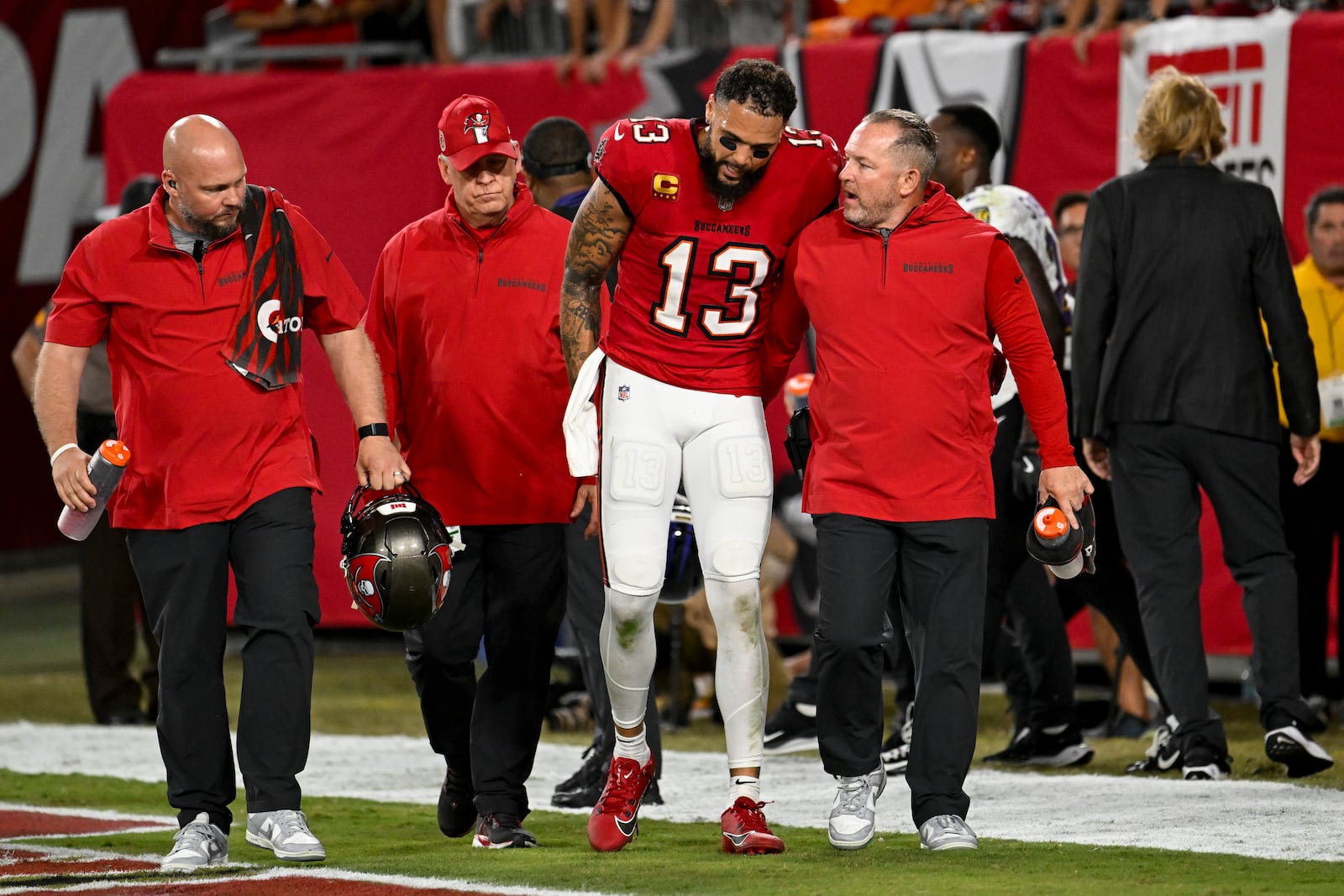 Tampa Bay Buccaneers wide receiver Mike Evans (13) is helped off the field after an injury during the first half of an NFL football game against the Baltimore Ravens, Monday, Oct. 21, 2024, in Tampa, Fla. (AP Photo/Jason Behnken)